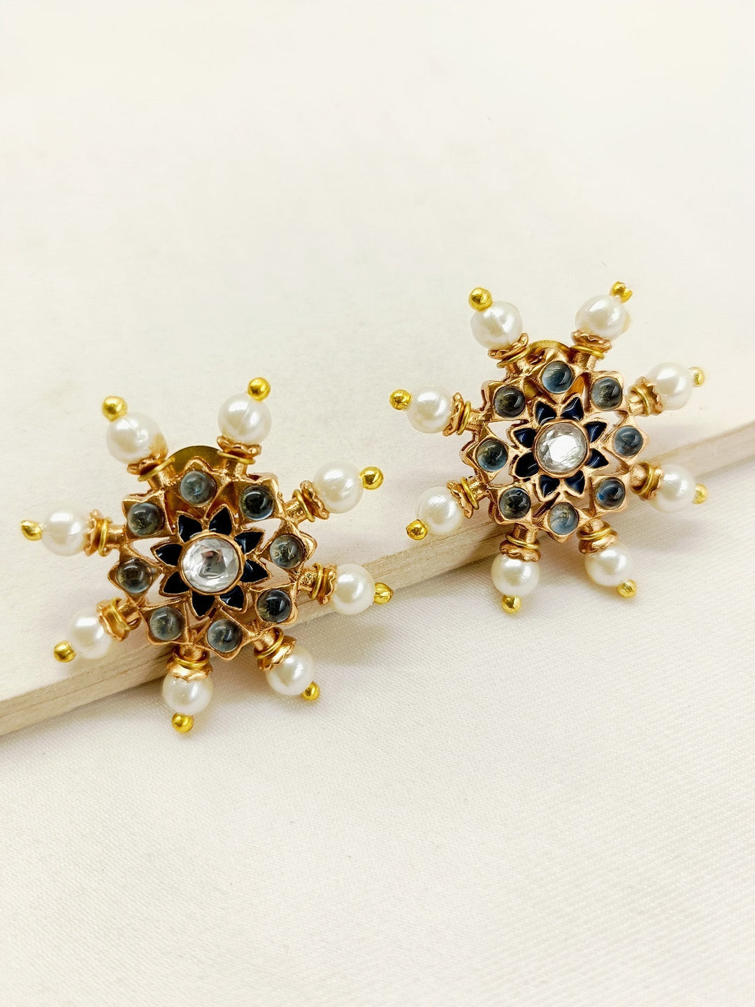 Close-up of a pair of Kalpana Navy Blue Gold Plated Meenakari Tops featuring beautiful traditional pearls and matte gold with turquoise navy blue stones