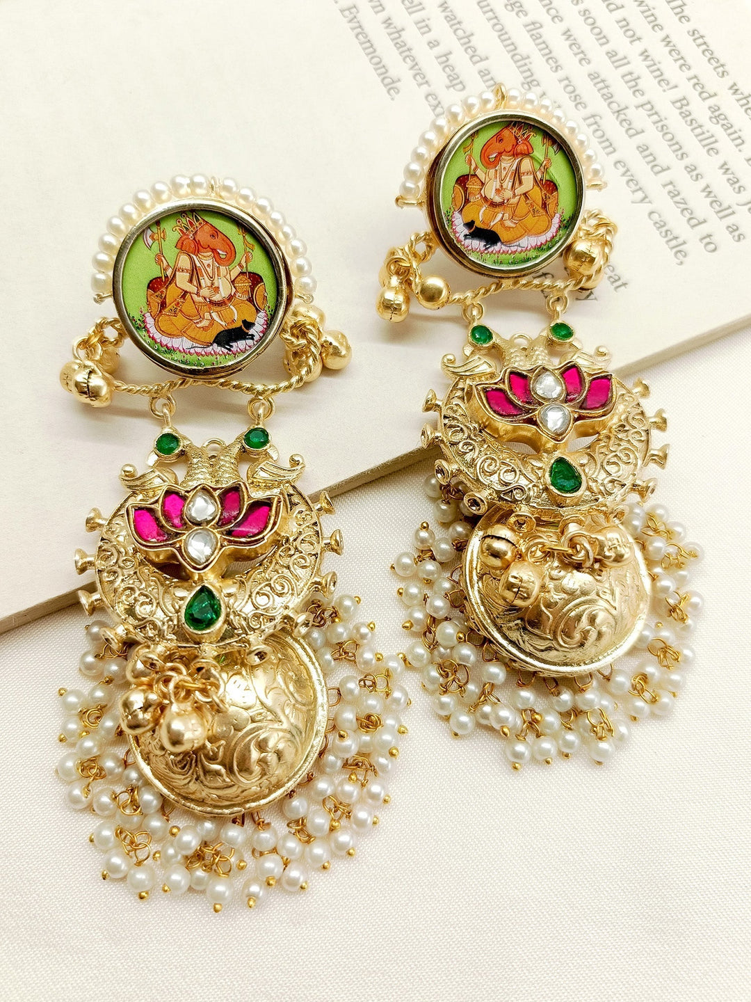 Handcrafted gold jhumki earrings with intricate design and sparkling stones