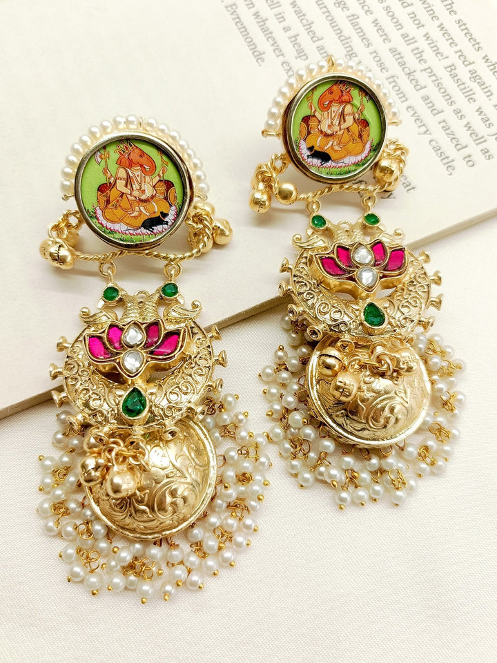 Handcrafted gold jhumki earrings with intricate design and sparkling stones