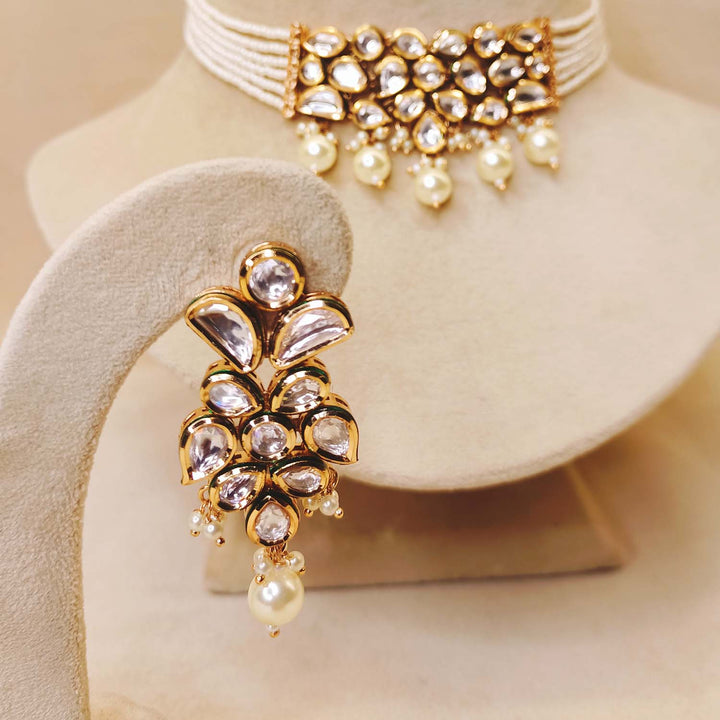 Intricate Kundan choker embellished with white pearls and paired with small Kundan earrings