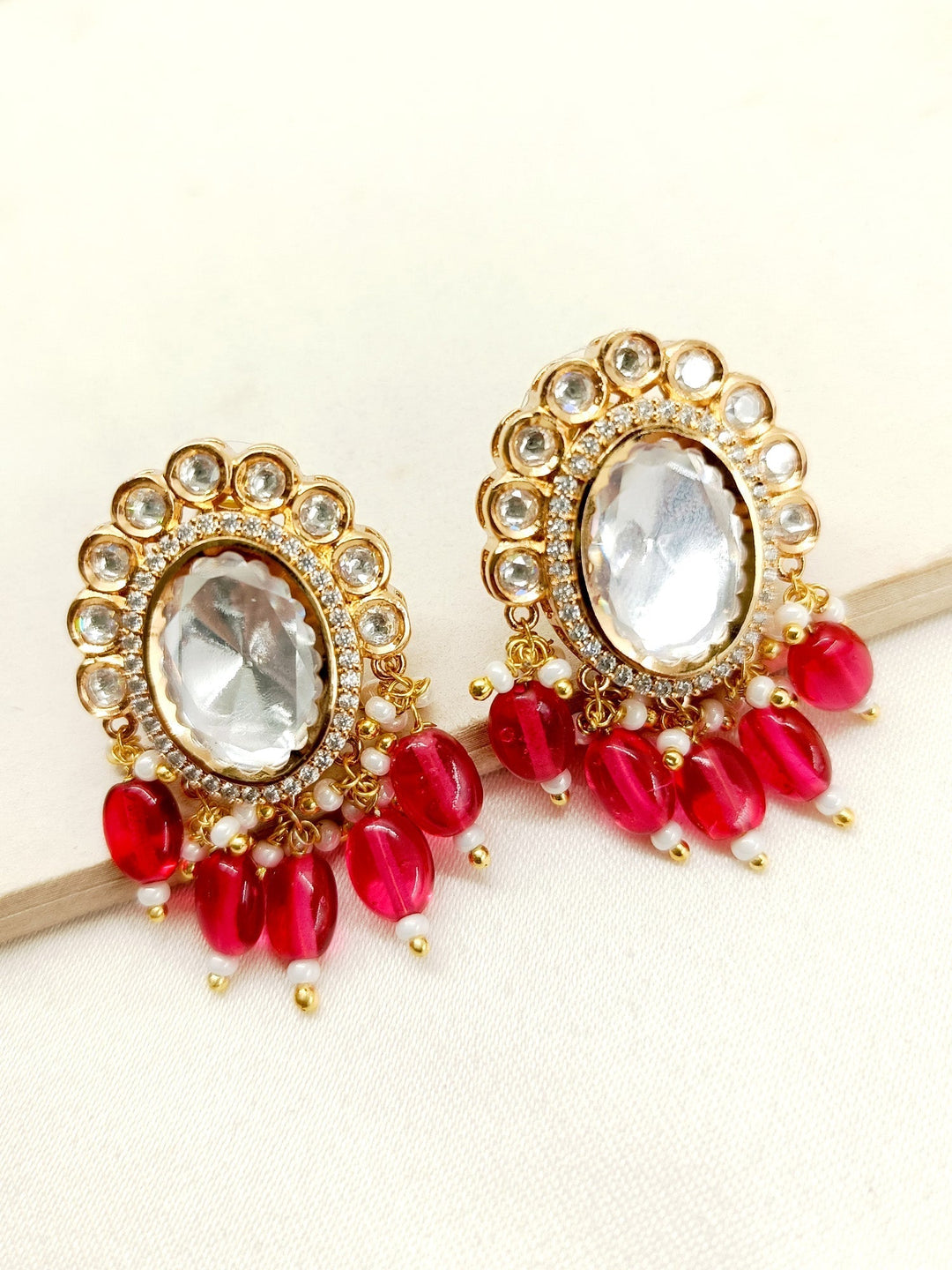 Gold plated Kundan earrings with intricate design and vibrant pink stones