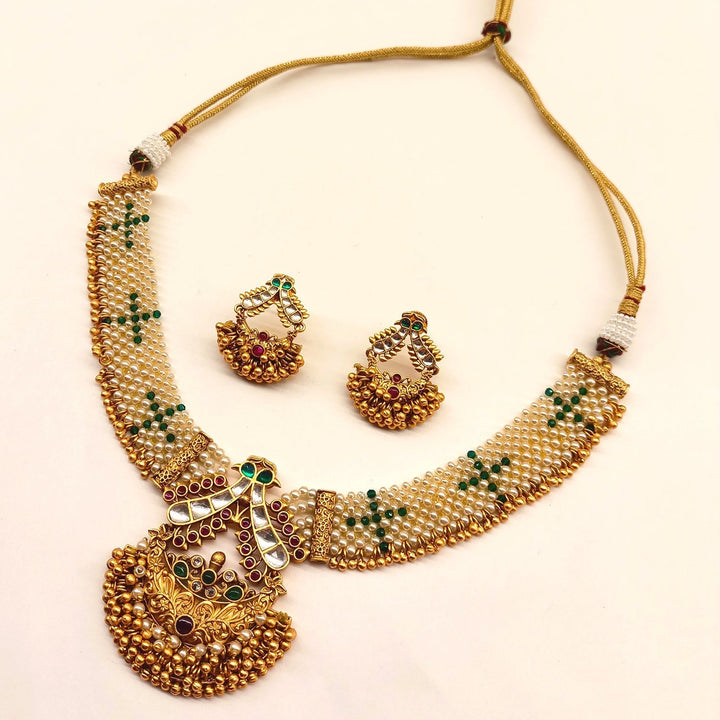 Beautiful rose pink and green stone temple work gold plated antique set with traditional Indian design and pretty earrings