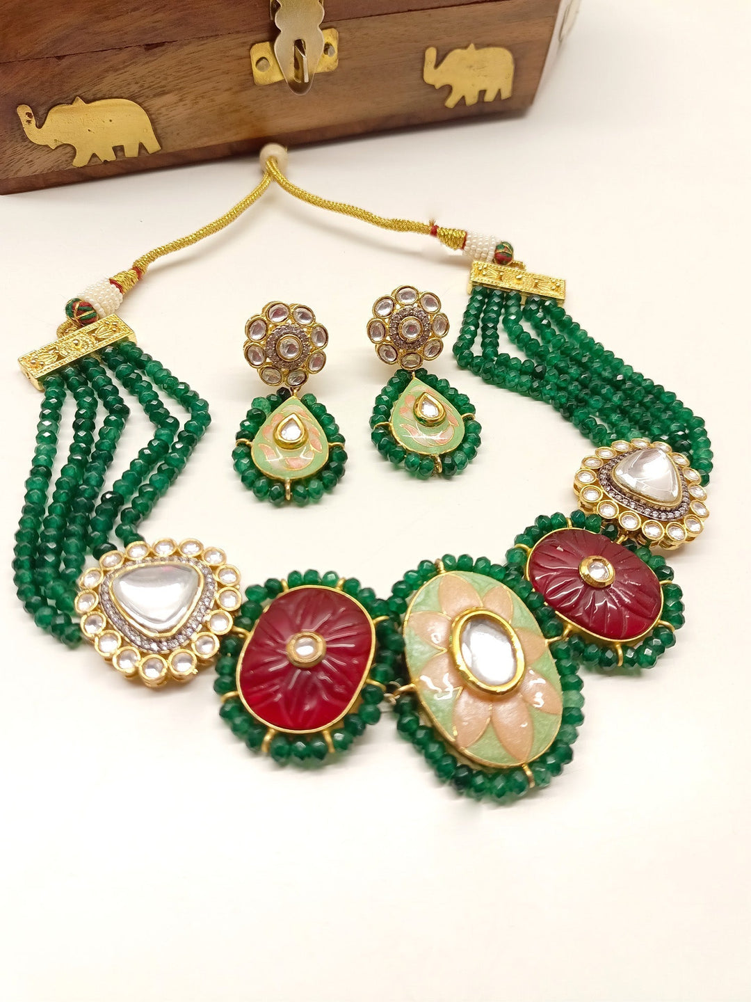 Gold and green Meenakari choker set with intricate design and embellishments
