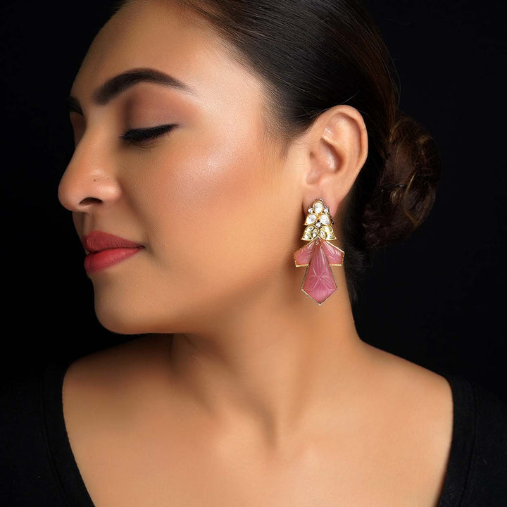 Beautifully designed Kundan and carving pink stones danglers earrings in gold and rhodium plating with brass metal and stone details 